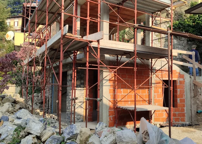 Foto di un edificio mentre sta venendo ristrutturato dall'azienda Casalino Engineering. Nella foto si può vedere l'edificio a mattoni rossi con i parapetti